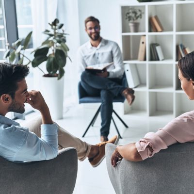 thervo-young-married-couple-talking-while-sitting-on-the-therapy-session-with-psychologist
